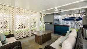 A covered outdoor seating area with wicker furniture, a coffee machine, and a blue umbrella. - Summer House - CANES, Three Bedroom, Two Bathroom, Second Row Community (Garden City Beach)