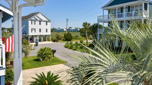 A coastal hotel with a two-story structure, a covered porch, and a view of the ocean. - Summer House - CANES, Three Bedroom, Two Bathroom, Second Row Community (Garden City Beach)