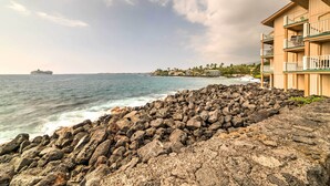 A coastal hotel with a rocky shoreline, a view of the ocean, and a distant ship. - Oceanfront Kailua-Kona Townhome w/ Pool & Views! (Kailua-Kona)