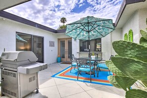 A patio with a grill, a table with chairs, and a colorful rug. - Rancho Mirage Condo on Fairway w/ Resort Amenities (Rancho Mirage)