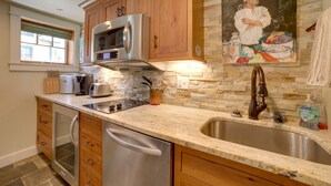 A kitchen with wooden cabinets, a stainless steel refrigerator, a microwave, a toaster, and a sink. - Pool Access: Pet-Friendly Pennsylvania Cabin! (Laughlintown)