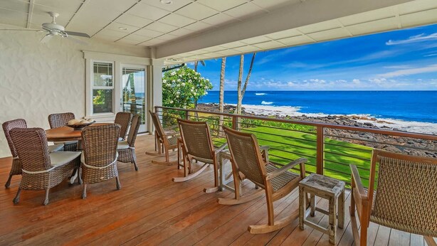 A wooden deck with wicker furniture overlooking a beach. - Hale Ilikai By Parrish Kauai: fabulous family location with oceanfront views and (Koloa)
