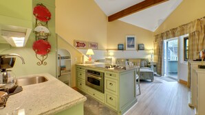 A kitchen with a built-in stove, a sink, and a dining area with a table and chairs.