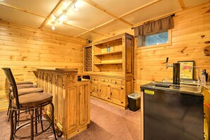 Un intérieur en bois comprenant un bar, des sièges et un réfrigérateur.