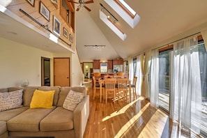 Relax in this spacious living area with a high ceiling and large window, perfect for a homey atmosphere.