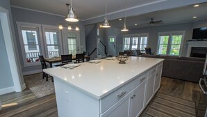A spacious kitchen with a large island, pendant lighting, and a view to the backyard. - 5 Bedroom Beachwalk Resort w/ Golf Cart & Pool Access (Michigan City)