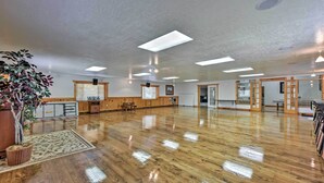 A spacious room with a polished wooden floor, ceiling lights, and a potted plant. - Huge Preston Cabin w/ Game Room & Mountain Views! (Preston)