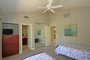 A bedroom with a ceiling fan, a dresser, a bed, and a painting on the wall. - Golf course-view 2BR condo in PGA West with pool, patio, and fireplace. (La Quinta)