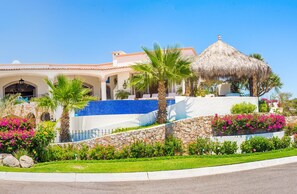 Ein Resort mit Pool, Palmen und einer Struktur mit Reetdach.