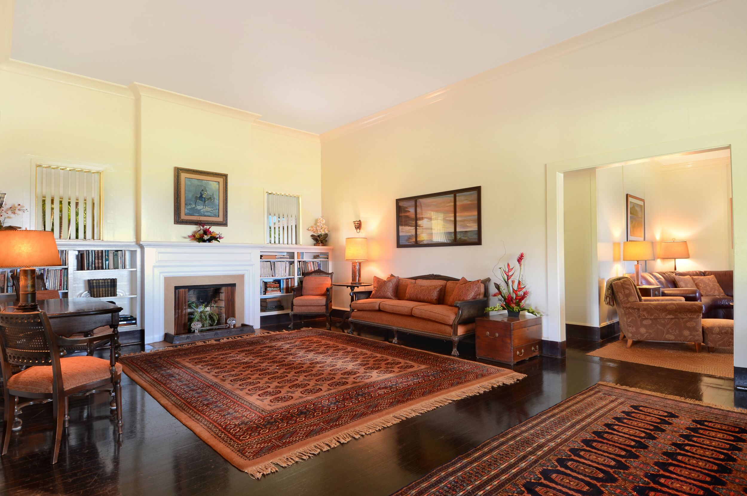 A spacious living room with a fireplace, a large rug, and a cozy seating area.