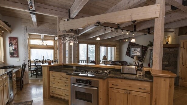 Una cocina amplia con armarios de madera, una isla central y un gran ventanal que proporciona luz natural.