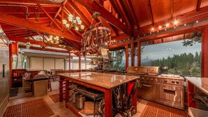 A spacious kitchen with a large island, stainless steel appliances, and a view of the outdoors.