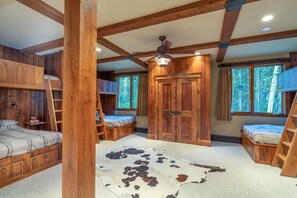 A rustic cabin interior with wooden walls, a ceiling fan, and a cowhide rug. - Walk-to-Ski Luxury Retreat | Hot Tub, Sauna, Gym & Serene Mountain Ridge Views (Mountain Village)