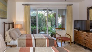 A hotel room with two beds, a TV, a wooden dresser, and a chair.