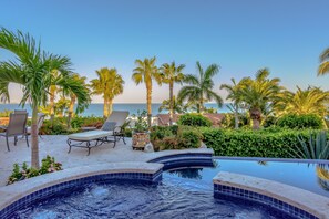 A pool area with lounge chairs and a view of the sea. - Luxury Villa Steps to Calm Palmilla Swimming Beach w/ Pool, Hot Tub & Ocean View (Cabo San Lucas)