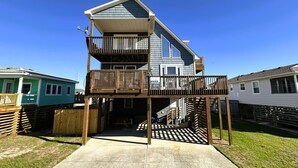 A two-story house with a balcony, a garage, and a visible driveway. - KD108- Near the Beach- 4 BRs, Just a Short Stroll to the Beach, Dog Friendly! (Kill Devil Hills)