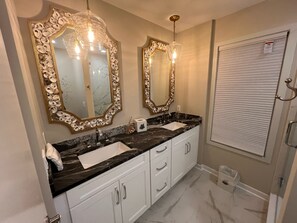 A bathroom with two large mirrors, a white sink, and a marble countertop. - Atlantis-Wonderful sound front home on the North End of Wrightsville Beach (Wrightsville Beach)
