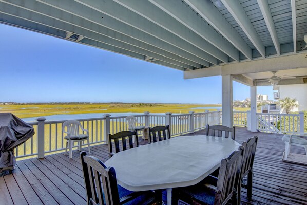A covered outdoor deck with a table and chairs, overlooking a beach and ocean. - Atlantis-Wonderful sound front home on the North End of Wrightsville Beach (Wrightsville Beach)