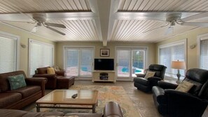 A living room with a TV, two sofas, a coffee table, and a fireplace. - Turtle Dunes 4 bedrooms, 3 bathroom (Jekyll Island)