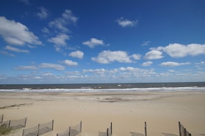 A beach with a wooden fence and a clear sky.