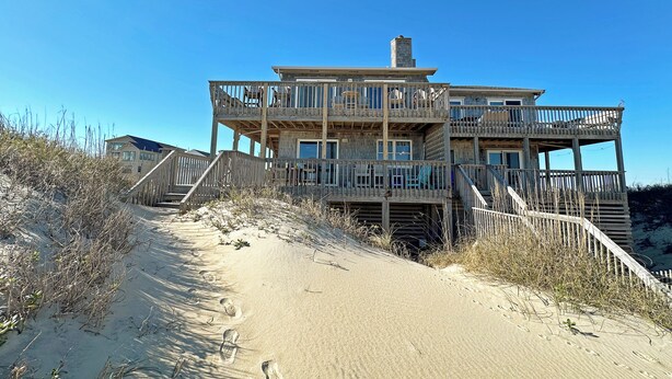 A wooden multi-story beach house with multiple balconies and a staircase leading to the entrance. - SN9241- Beautiful Oceanfront Home with Great Ocean Views and Dog Friendly! (Nags Head)