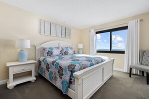 A bedroom with a bed, two bedside tables, a chair, a window with a view, and a wall with artwork. - *20% Off New Summer 2026 Bookings* (Garden City)