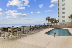 A pool area with lounge chairs and a pool, surrounded by a wooden deck and a fence. - *Fall into Savings-20% Off New Bookings thru 2026* (Garden City)