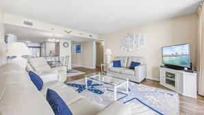 Ein modernes Wohnzimmer mit Sofa, Couchtisch und Fernseher.