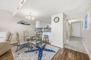 A compact living space with a dining area, kitchenette, and a hallway leading to a door. - *Fall into Savings-20% Off New Bookings thru 2026* (Garden City)