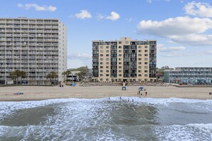 A beachfront hotel with multiple floors, a sandy beach in the foreground, and a clear sky. - *Fall into Savings-20% Off New Bookings thru 2026* (Garden City)