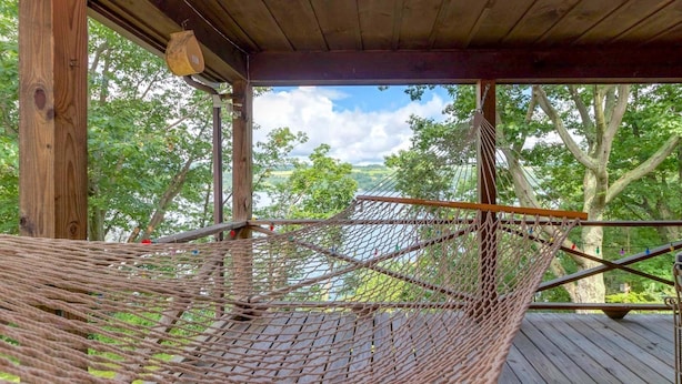 A hammock under a wooden structure with a view of trees and a body of water. - Wine to Water - Family Adventure on Keuka Lake Awaits! (Hammondsport)
