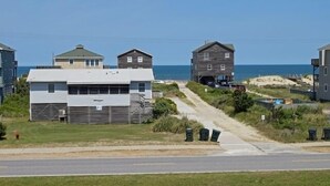 Un área residencial costera con casas, una carretera y una playa al fondo.
