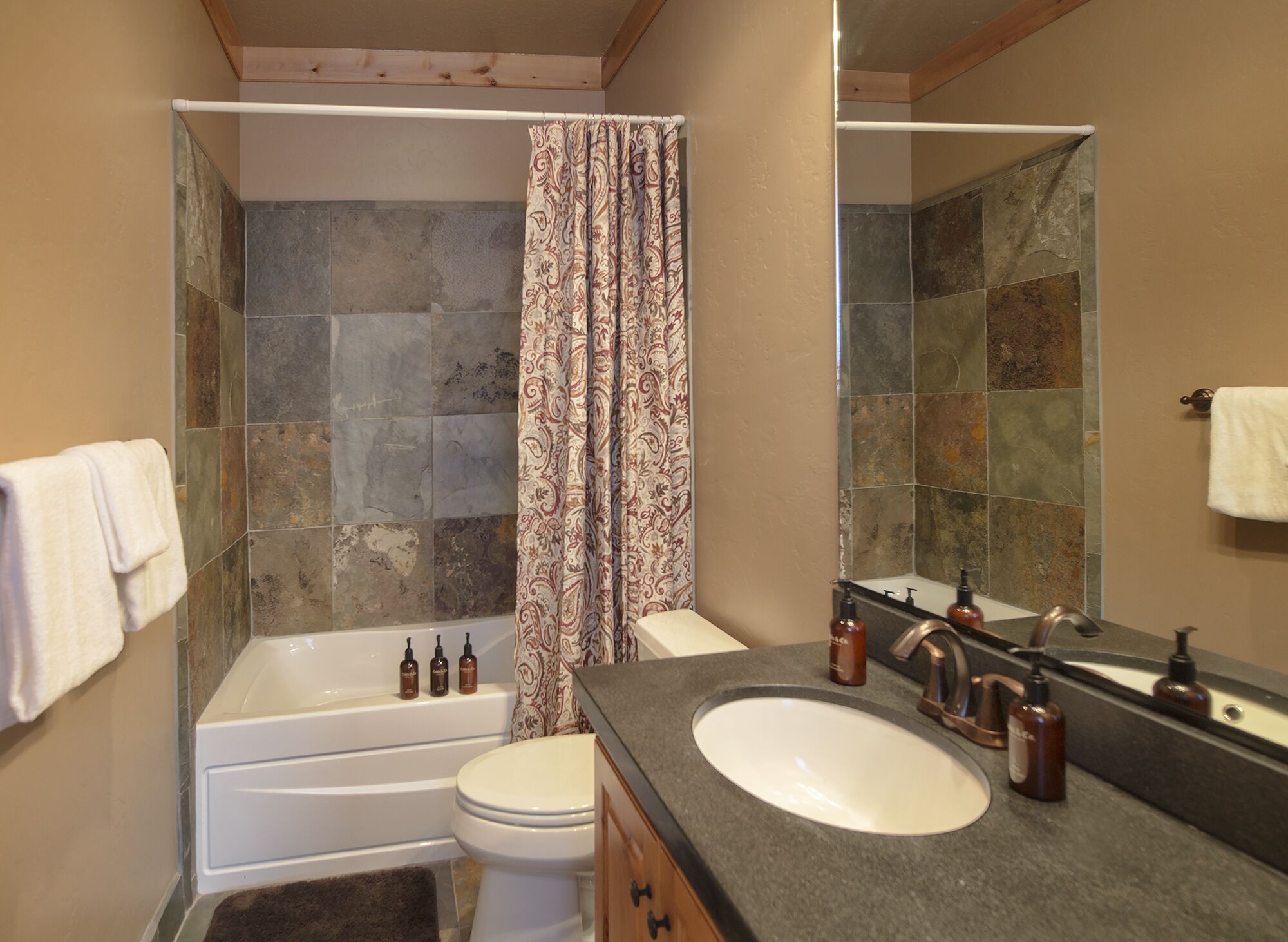 A bathroom with a bathtub, toilet, and sink.