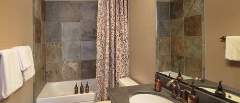 A bathroom with a bathtub, toilet, and sink.