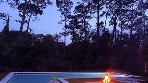 Ein Pool mit Feuerstelle und einem Kinderspielbereich.