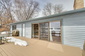 Ein modernes Haus mit Terrasse, großen Schiebegläsern und Seeblick.