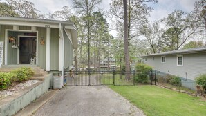 Een woonhuis met een veranda, een poort en een gazon.