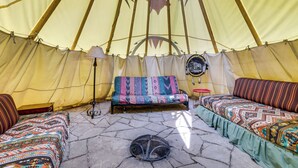 A tent with a central seating area, a small table, and a fire pit. - Colorful Cabin w/ Teepee, Fire Pits & Mtn Views! (Marble)
