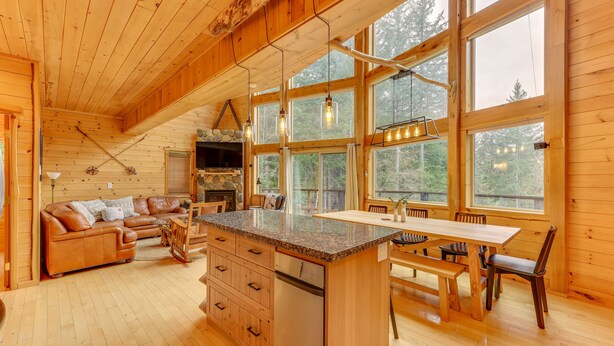 L'interno di una baita in legno con cucina, sala da pranzo e soggiorno.
