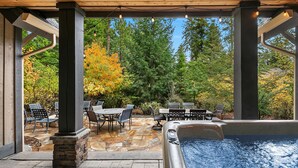 An outdoor patio area with stone flooring, a hot tub, and outdoor furniture. - Luxurious Buttercup Manor in Suncadia! Game Room | Hot Tub | Pet Friendly (Cle Elum)