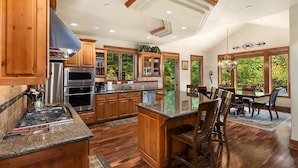 A spacious kitchen with wooden cabinets, granite countertops, and a central island. - Luxurious Buttercup Manor in Suncadia! Game Room | Hot Tub | Pet Friendly (Cle Elum)