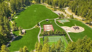 Une vue aérienne d’un terrain de golf avec plusieurs greens, un court de tennis et un terrain de baseball.