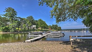 A lakeside dock with boats, a rocky shore, and buildings in the background. - 1 Mi to Lake Wallenpaupack: Pocono Mountain Home! (Greentown)