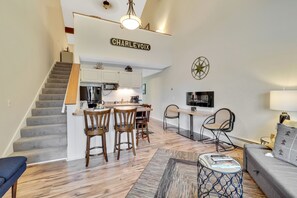 Un appartement moderne comprenant un escalier, une cuisine, un coin repas et un salon.