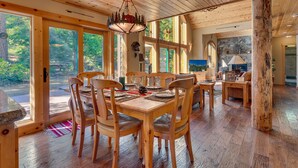 A wooden dining area with a table set for six, surrounded by chairs. - Tippy Canoe By Tahoe Getaways - Hot Tub & Sauna + EV Charger (Tahoma)
