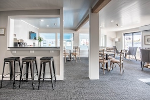 Una hall d'hotel moderna con un'area bar, posti a sedere e vista sulla città.