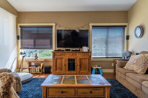Un salon avec un téléviseur, un meuble en bois et un canapé.