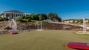 Ein Golfplatz mit Clubhaus, einer roten Bank und einer Steintreppe, die zum Gebäude hinaufführt.