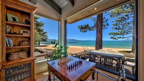 A room with a chessboard, a bookshelf, and a view of the beach and ocean. - Lakefront Beauty + On Water, Lakeland Village #610 (South Lake Tahoe)