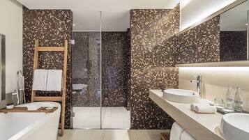 A modern bathroom with a large bathtub, a shower with a glass door, and a vanity with two sinks.